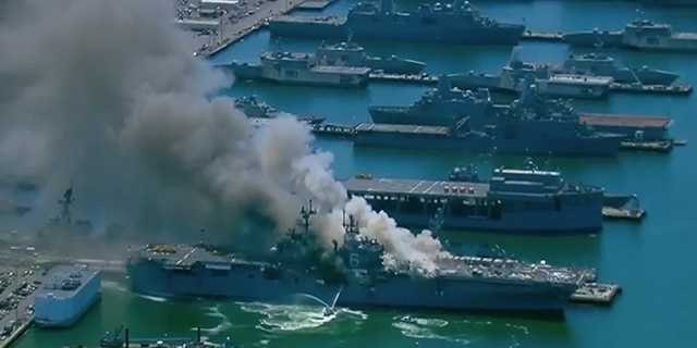 Firefighters on land, in the air and on the water on Monday were still battling a blaze on a Navy ship that injured at least 21 people and sent smoke billowing over San Diego.